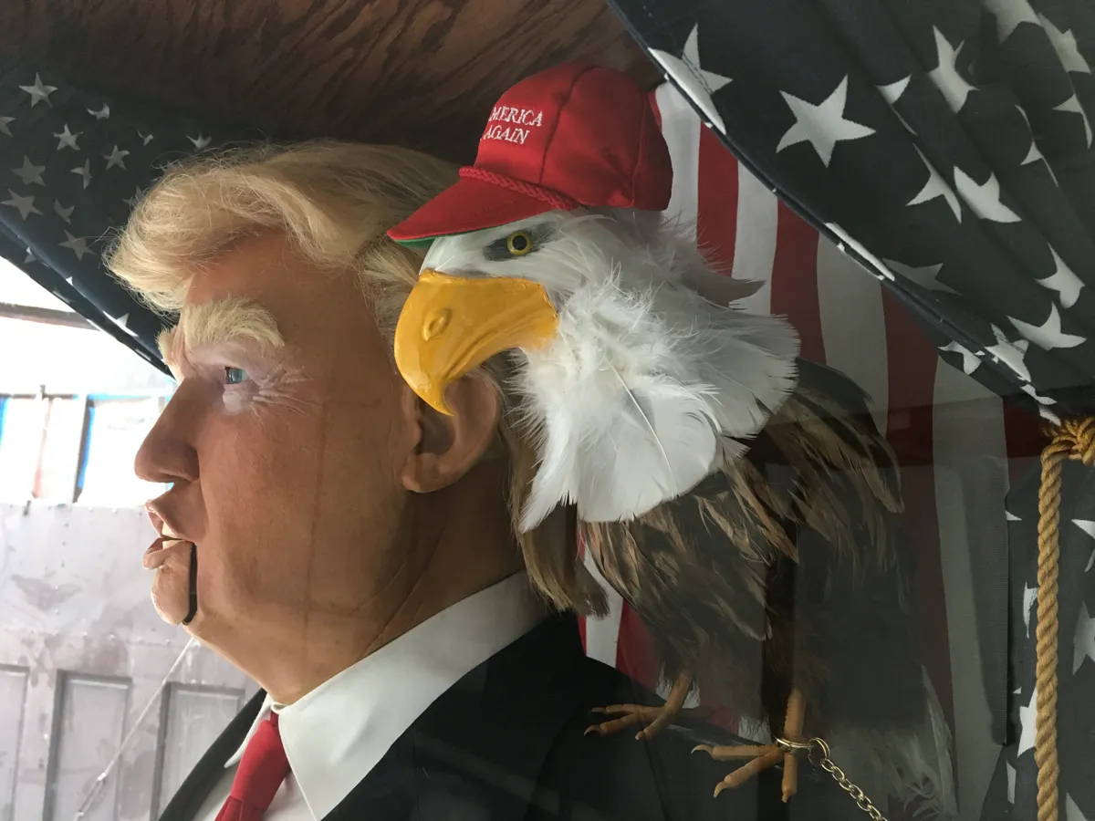 Profile of the animatronic Trump head, the MAGA-hatted eagle perched at his shoulder